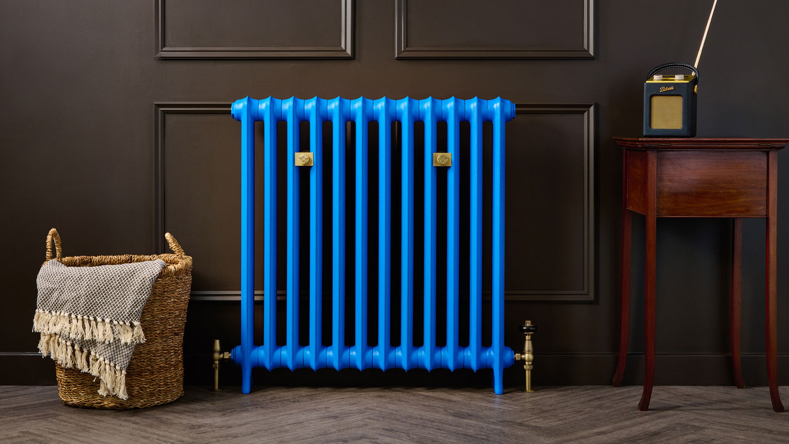 Blue old style column radiator against a dark panelled wall