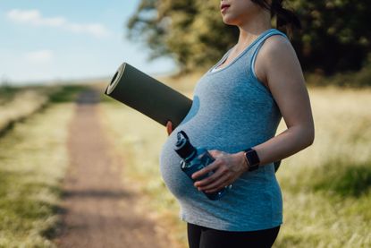 Can you workout while pregnant?: A woman with a baby bump exercising