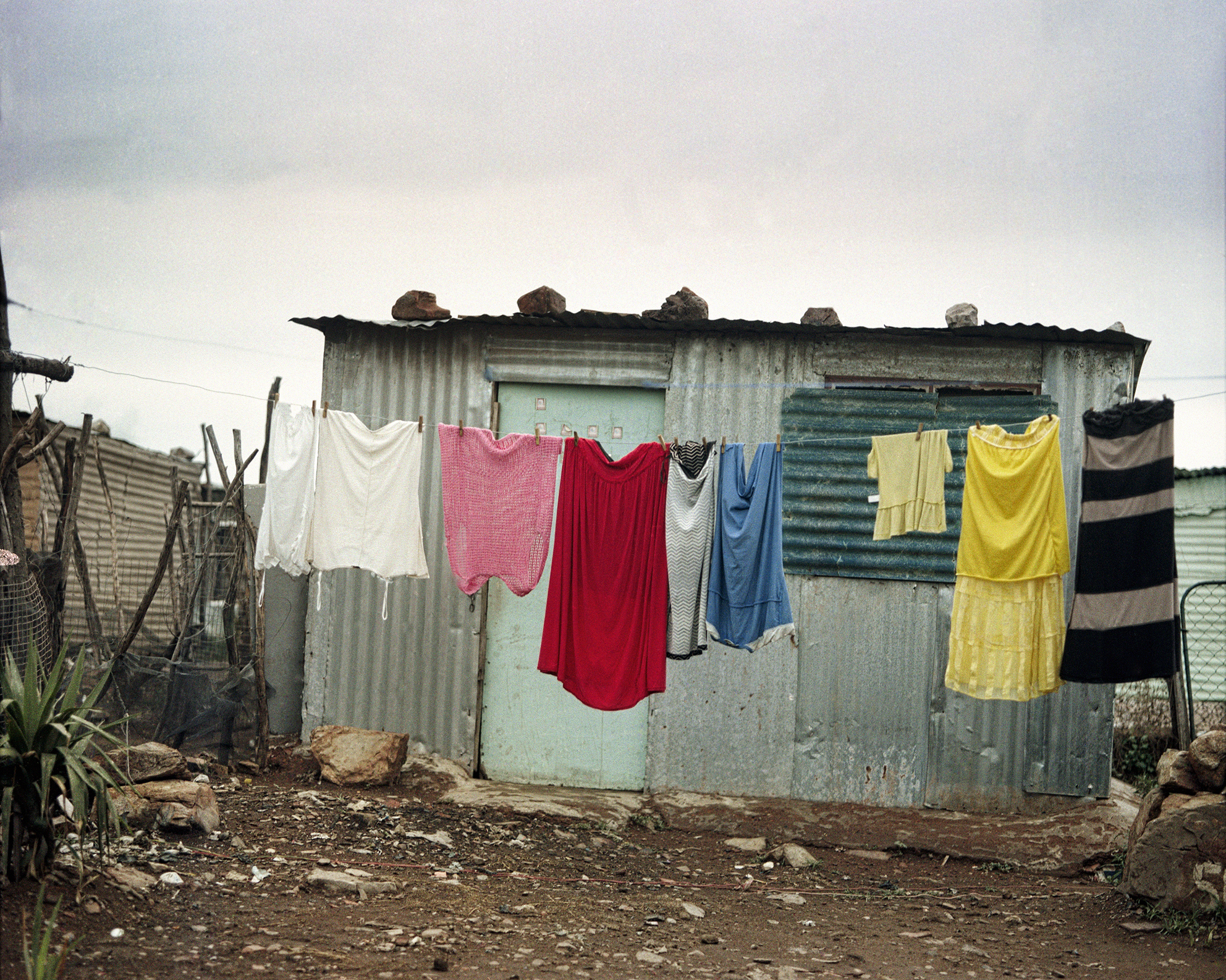 Color photograph of a laundry line with colored clothes hung up on it