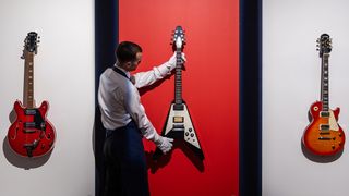 A selection of guitars owned and used by Noel Gallagher, including (l-r) an Epiphone EA-250, a Gibson Flying V and an Epiphone Les Paul Standard electric guitar, go on view at Sotheby's on September 09, 2024 in London, England