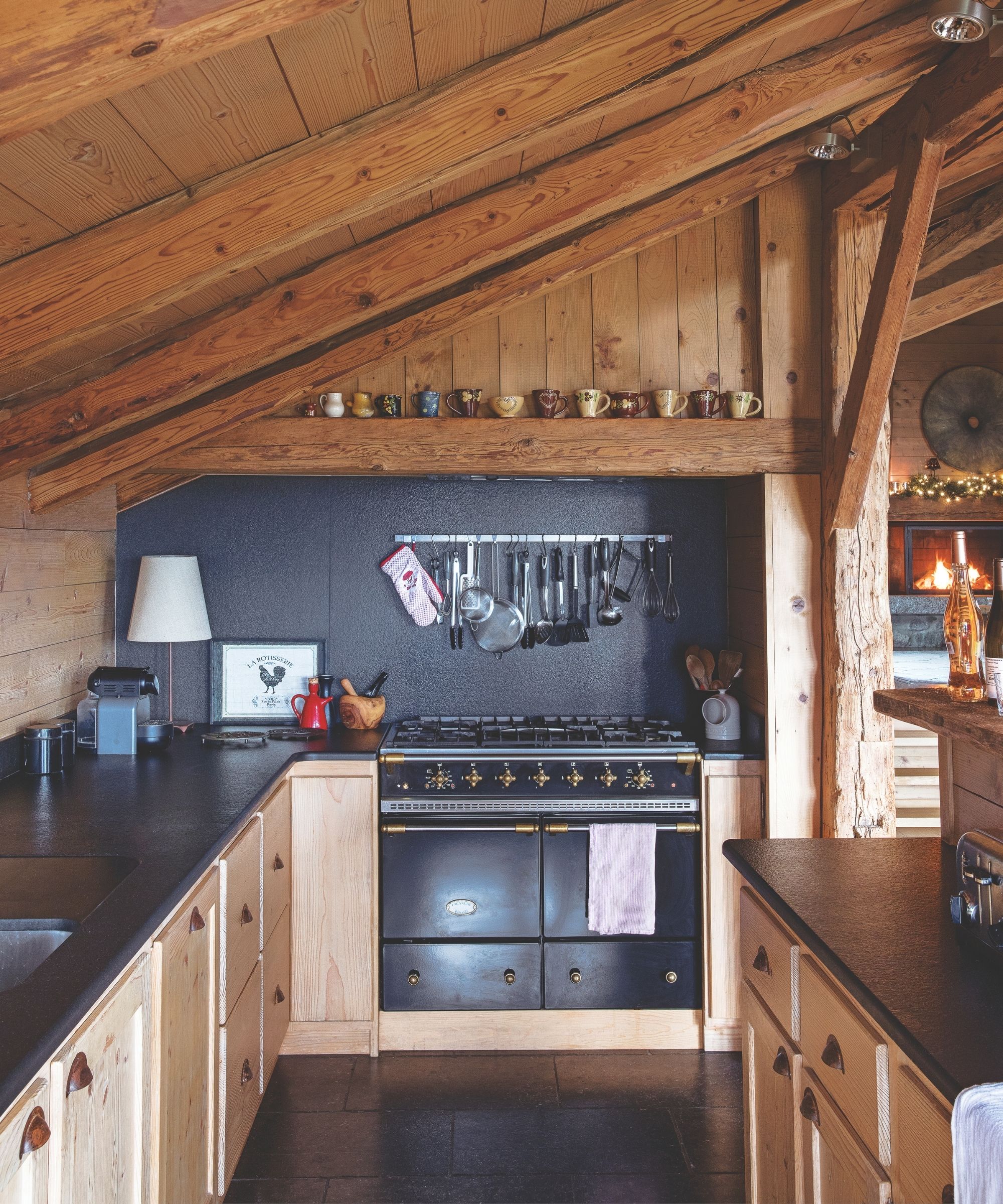 Wood panelled kitchen with black oven and wooden cabinetry