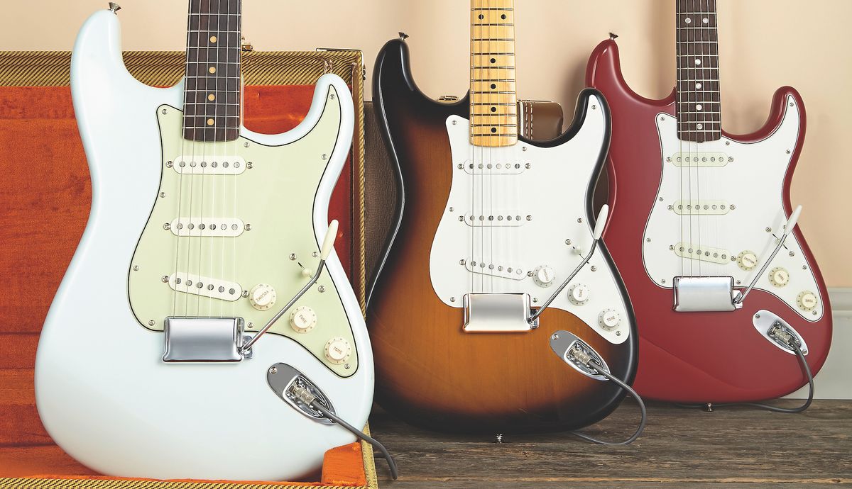 Three Fender Stratocasters, sat upright