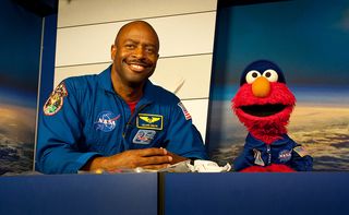 Former astronaut Leland Melvin helps Elmo