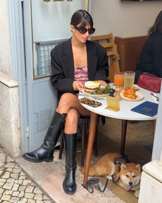 french woman wearing dress, blazer, and black boots