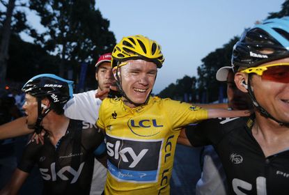 Tour de France 2013 winner Britain's Christopher Froome (C) celebrates with teammates on the Champs-Elysee avenue in Paris, after finishing the 133.5 km twenty-first and last stage of the 100