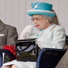 Queen Elizabeth applying lipstick