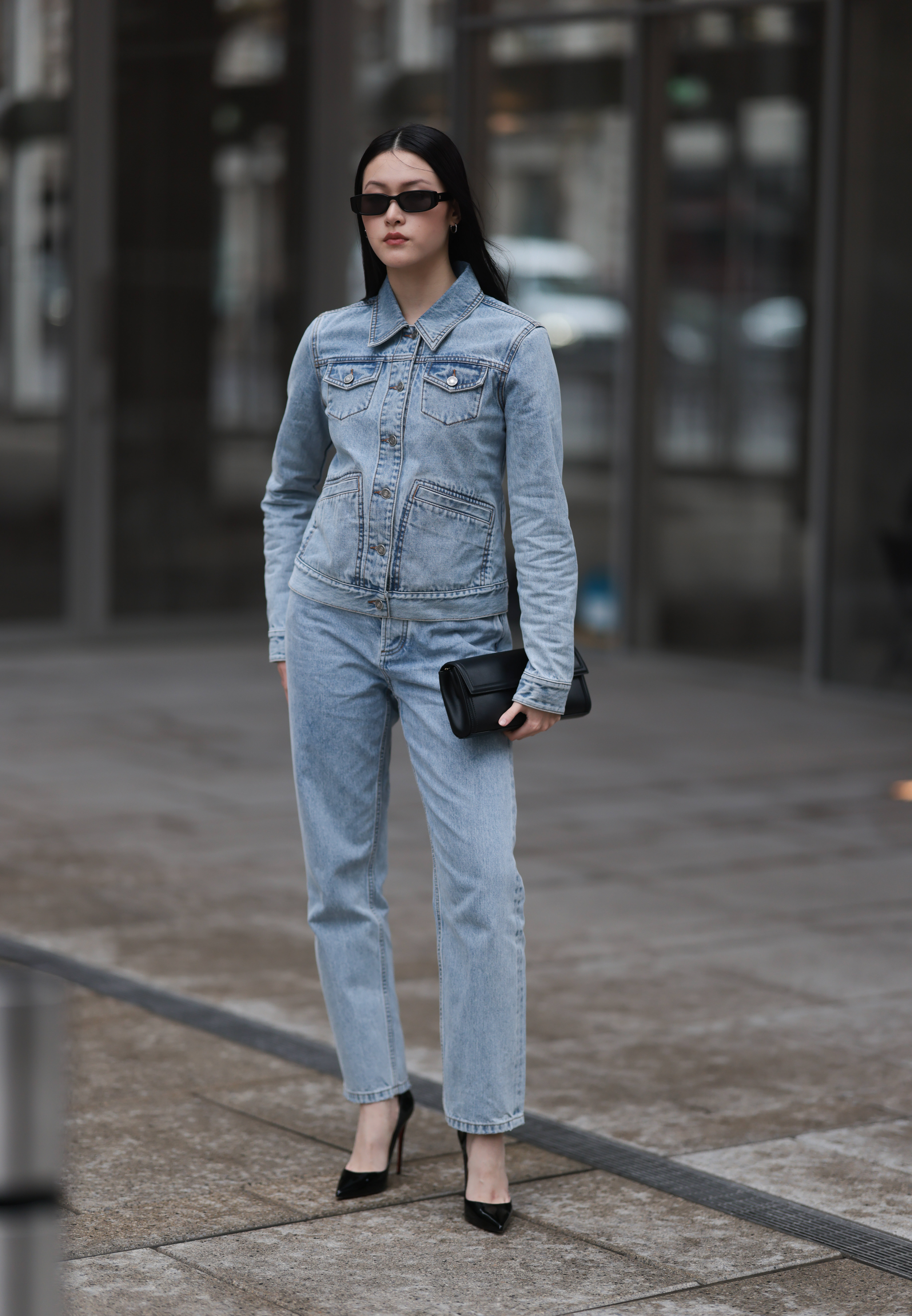 Woman wearing light wash denim outfit during fashion week.