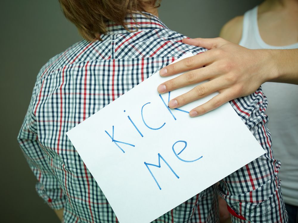 A guy with a &#039;Kick Me&quot; sign on his back. 