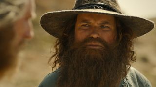 Tom Bombadil looks at an out-of-focus Stranger in The Rings of Power season 2