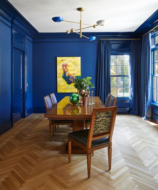 Blue dining room with high gloss walls and wooden flooring