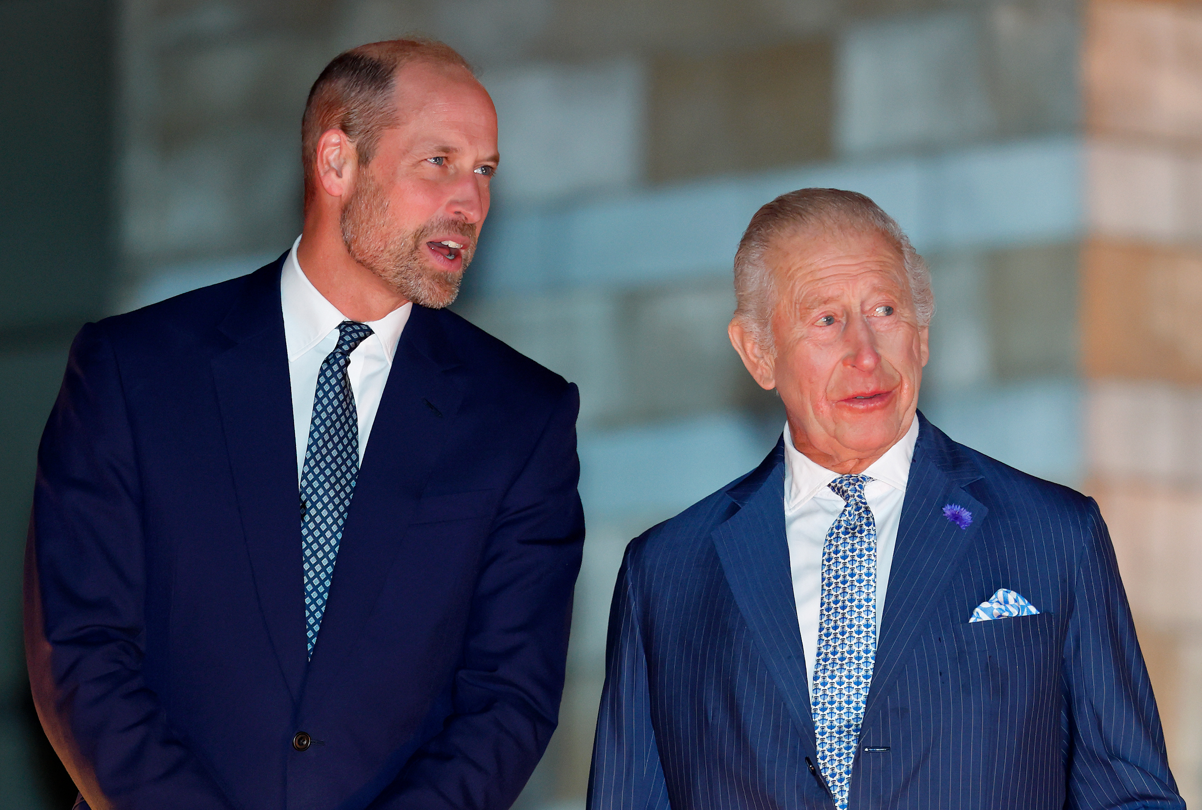 Prince William and King Charles wearing blue suits and ties