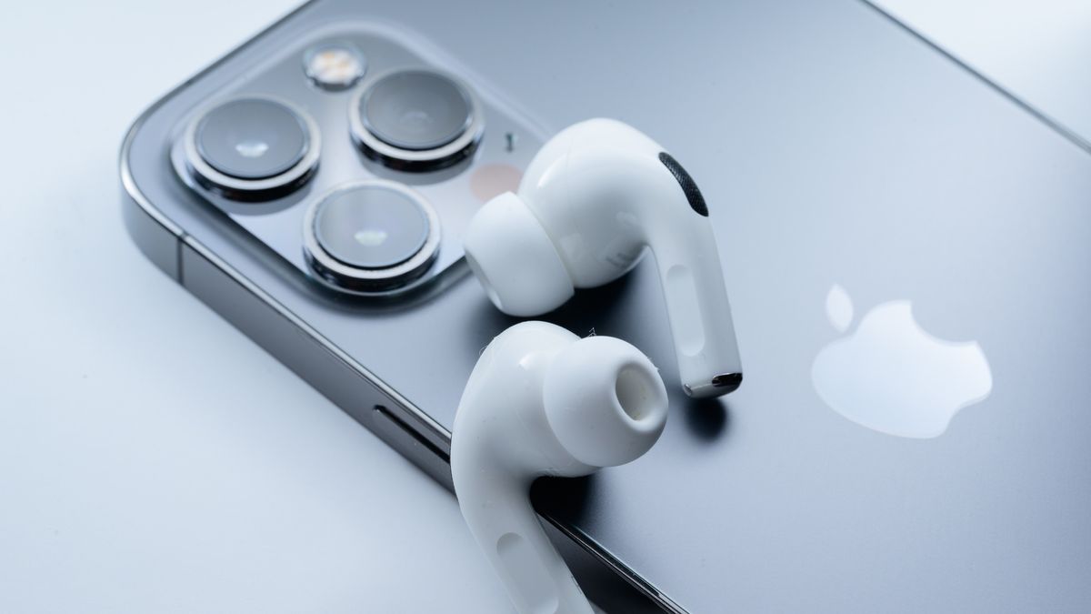 Apple AirPods Pro 2 on top of iPhone on gray backgorund