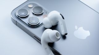 Apple AirPods Pro 2 bovenop een iPhone tegen een grijze achtergrond