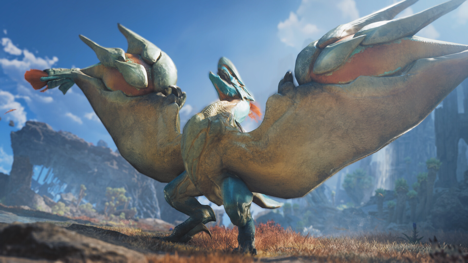 A large, winged creature with golden scales and teal accents stands in a grassy, rocky landscape under a bright blue sky, spreading its wide wings.