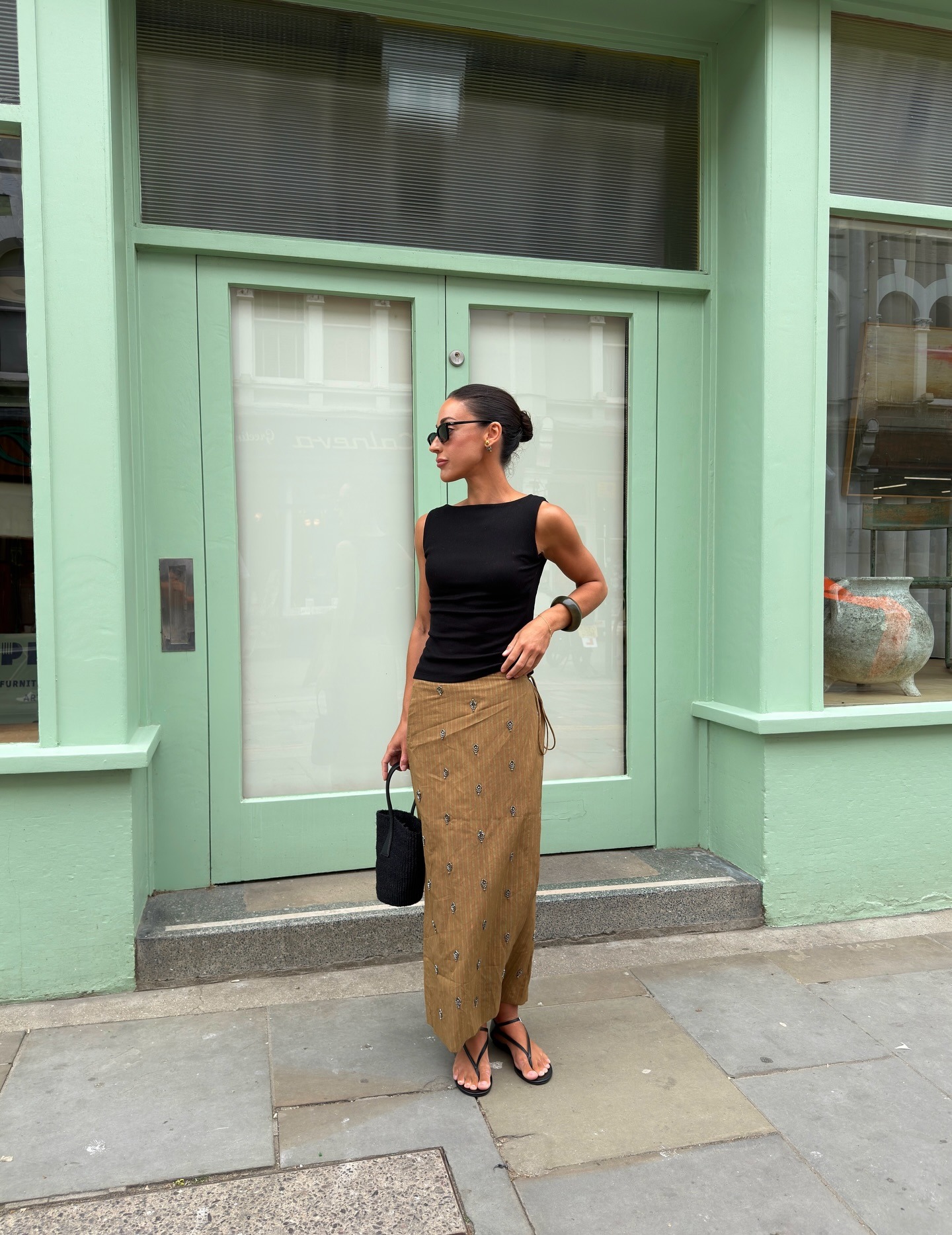 Woman in black top and scarf pareo skirt.