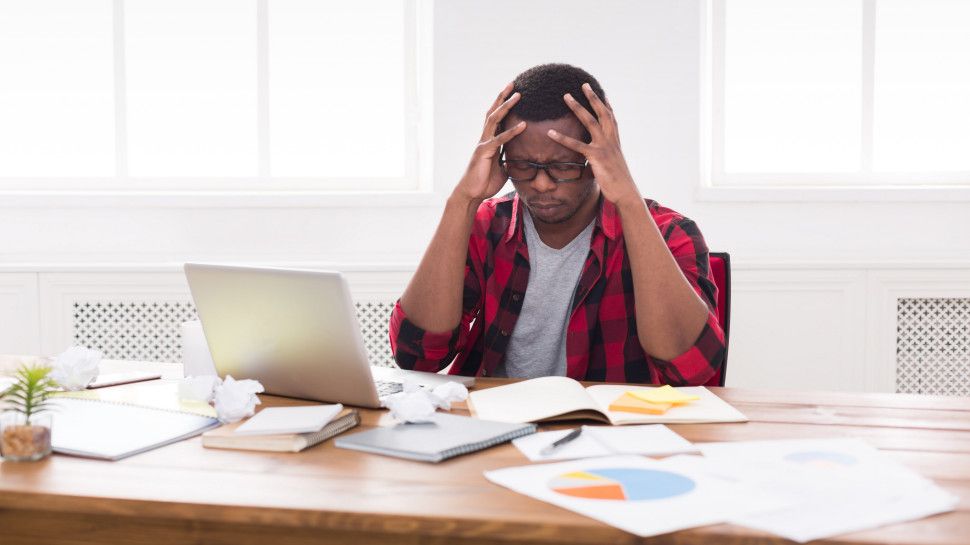 A frustrated man looking at a laptop