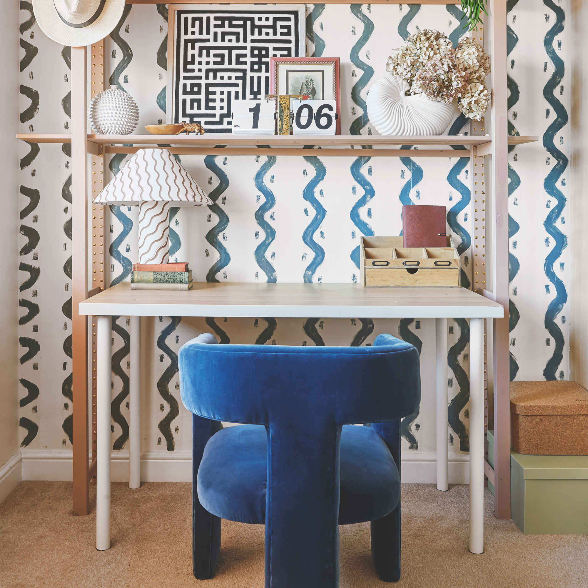 modern home office ideas, home office with modern wallpaper behind desk and shelving, blue velvet chair