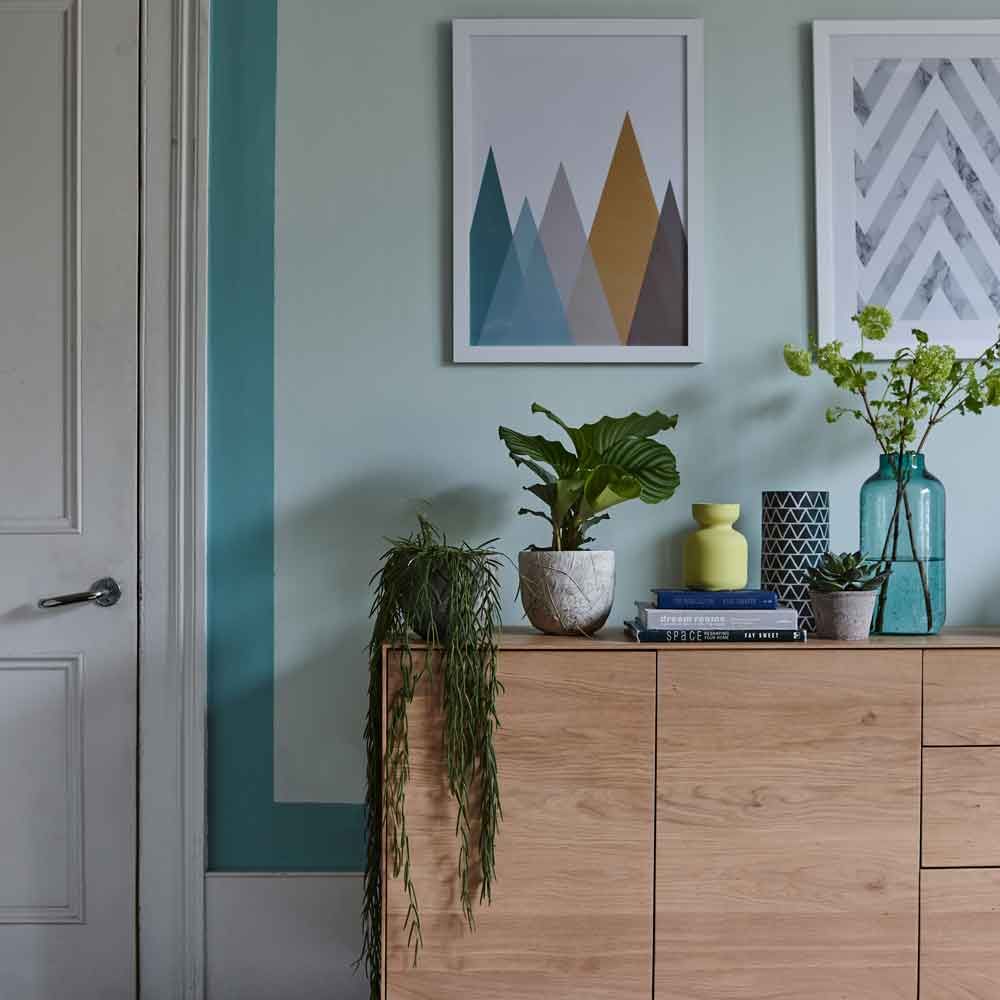 doorframe with painting on wall and flower jar on table