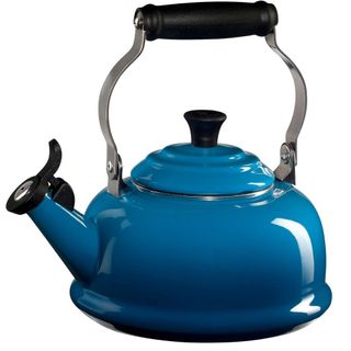 blue whistling kettle from le creuset on a white background