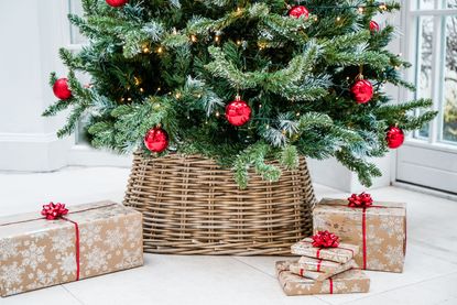 A close up of a Christmas tree with a wicker skirt