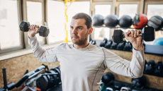 Man doing beginner dumbbell workout: dumbbell shoulder press