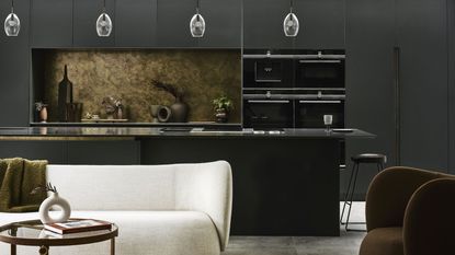 dark kitchen with bronze splash back and white sofa