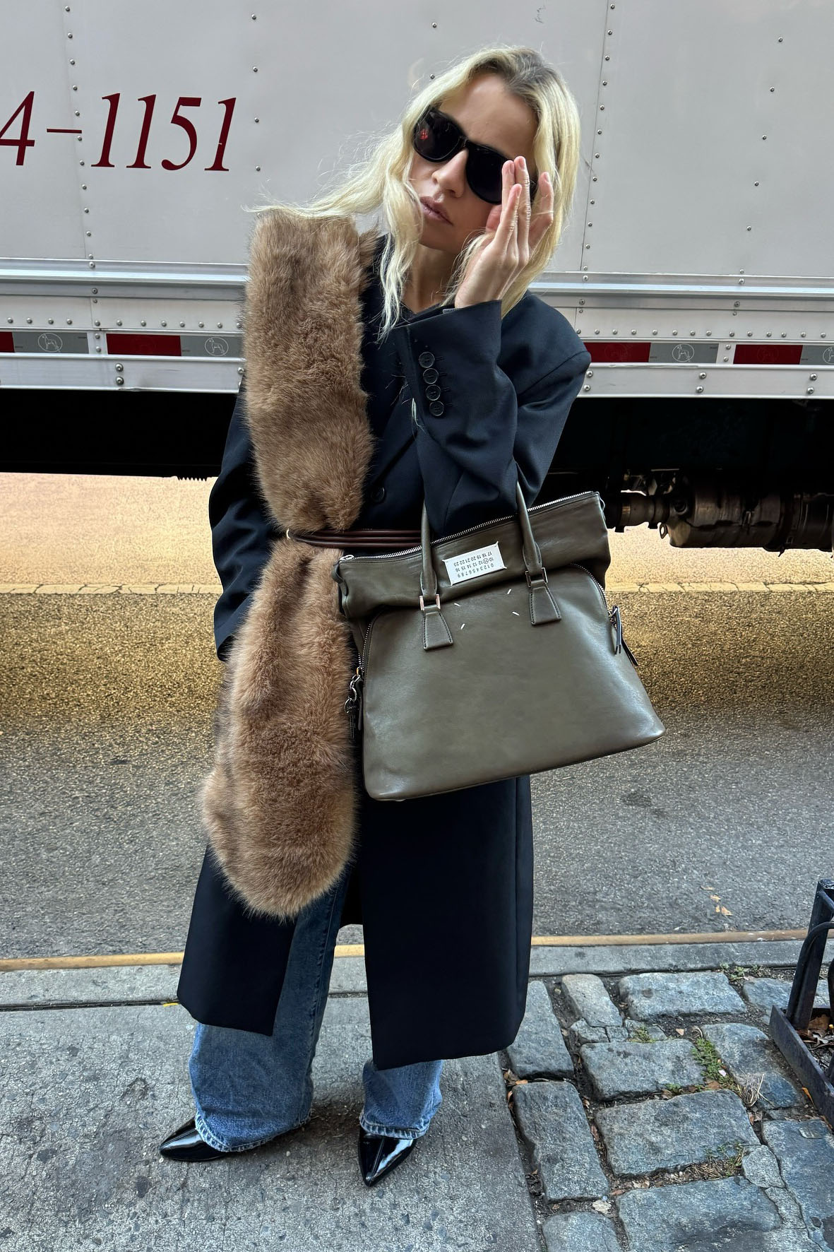 a woman wearing a black coat and fur scarf