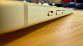 A yellow iPhone 15 on a wooden desk