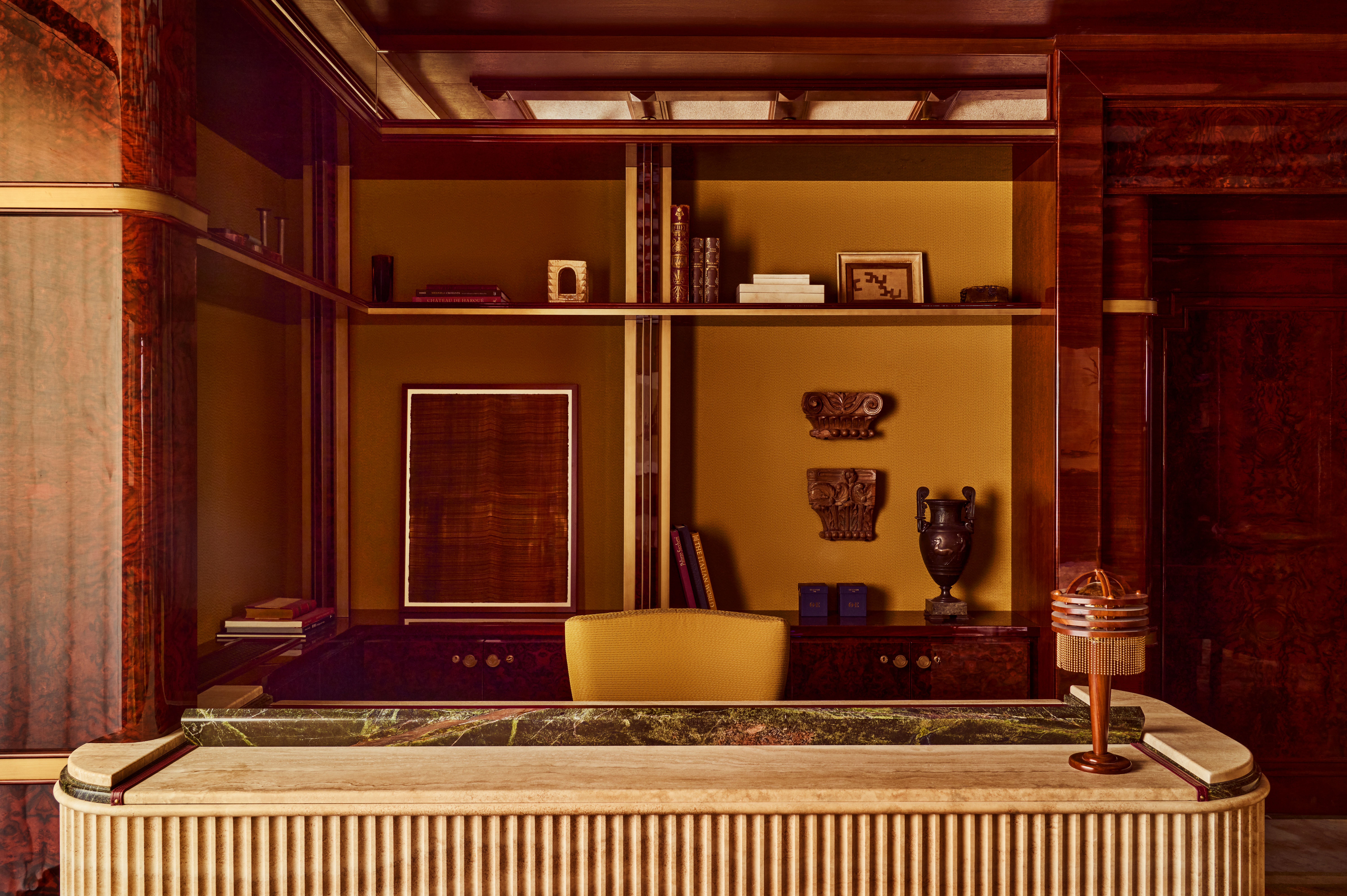 The interiors of a palatial hotel housed inside a 16th-century building with frescoed walls, textural arches, mesmerizing flooring, and plenty of wood oozes antique-inspired furniture and a golden atmosphere across sculptural furnishings, artworks, and plants.