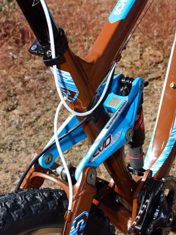 Housings are crossed behind the seat tube to keep them out of the way as the suspension compresses. The unused front derailleur housing stops are used for the seatpost remote.