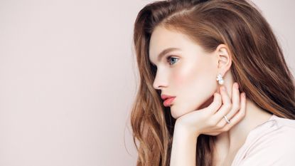 Studio shot of young beautiful woman with earrings and ring