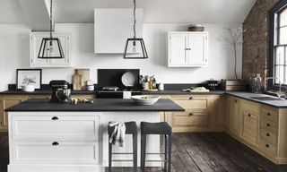 An L shaped white kitchen with wooden benches and black worktops by neptune