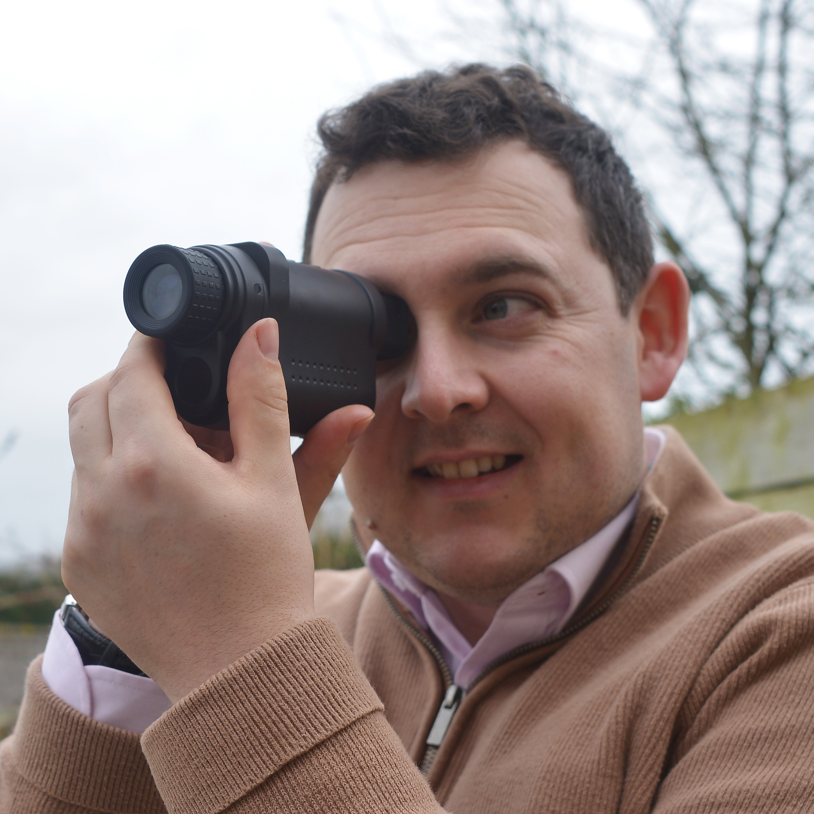 Sebastian Oakley, our optics expert holding a Monocular to his eye