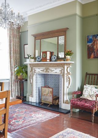 living room with mirror and ornate fireplace with chandelier and arm chair
