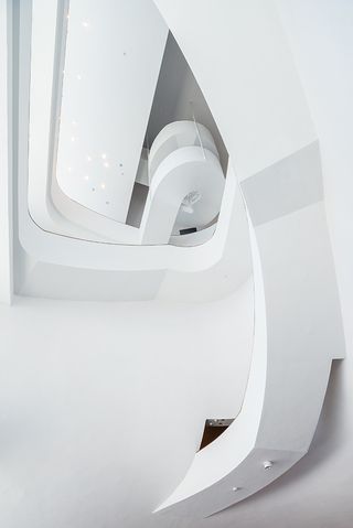 White interior of the National Taichung Theater with curved walls and staircases