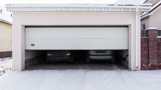 Garage door half open on snowy day 