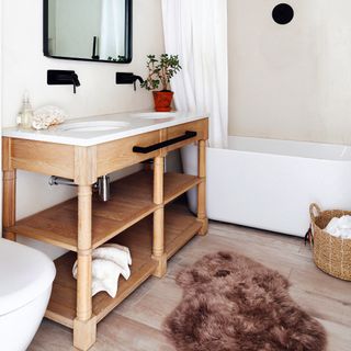 White bathroom with double sink and brown rug