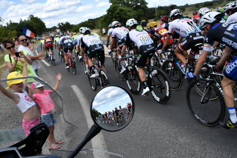 Young fans cheer the riders as the Tour de France peloton passes by