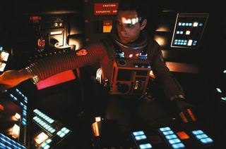 Screenshot from 2001: A Space Odyssey with David Bowman at a control centre.
