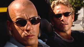 Vin Diesel and Paul Walker sitting in a car wearing sunglasses.