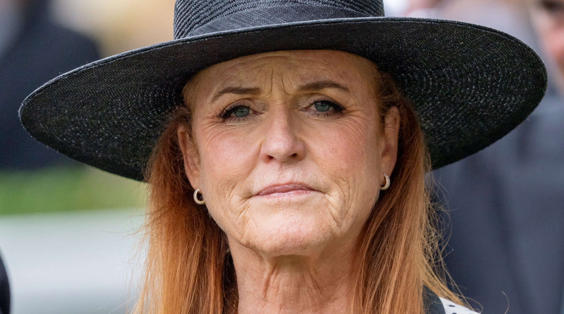 Sarah Ferguson attending Ascot 2025 wearing a black and white polka dot dress with a wide-brim black hat, she has red hair