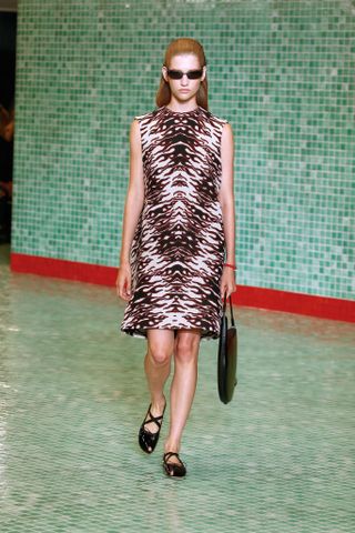 A model wearing a printed dress on the catwalk