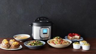 An InstantPot duo surrounded by food, including potatoes and a cheesecake