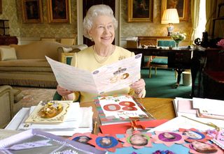 The Queen's birthday: HRH Queen Elizabeth II sits in the Regency Room at Buckingham Palace in London, April 20, 2006, as she looks at some of the cards which have been sent to her for her 80th birthday.