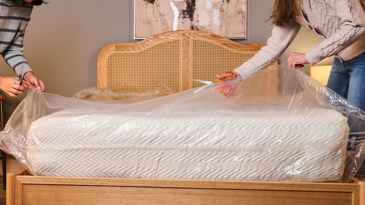 Testers cut the plastic wrapping of the newly expanded Leesa Legend Hybrid Mattress.