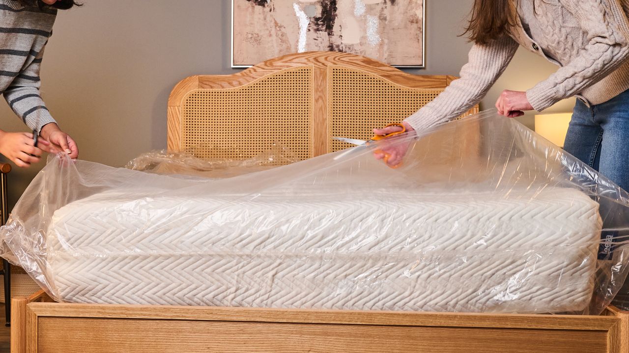 Testers cut the plastic wrapping of the newly expanded Leesa Legend Hybrid Mattress.