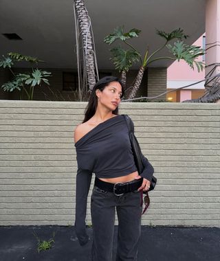 woman wearing black off the shoulder top and light black jeans