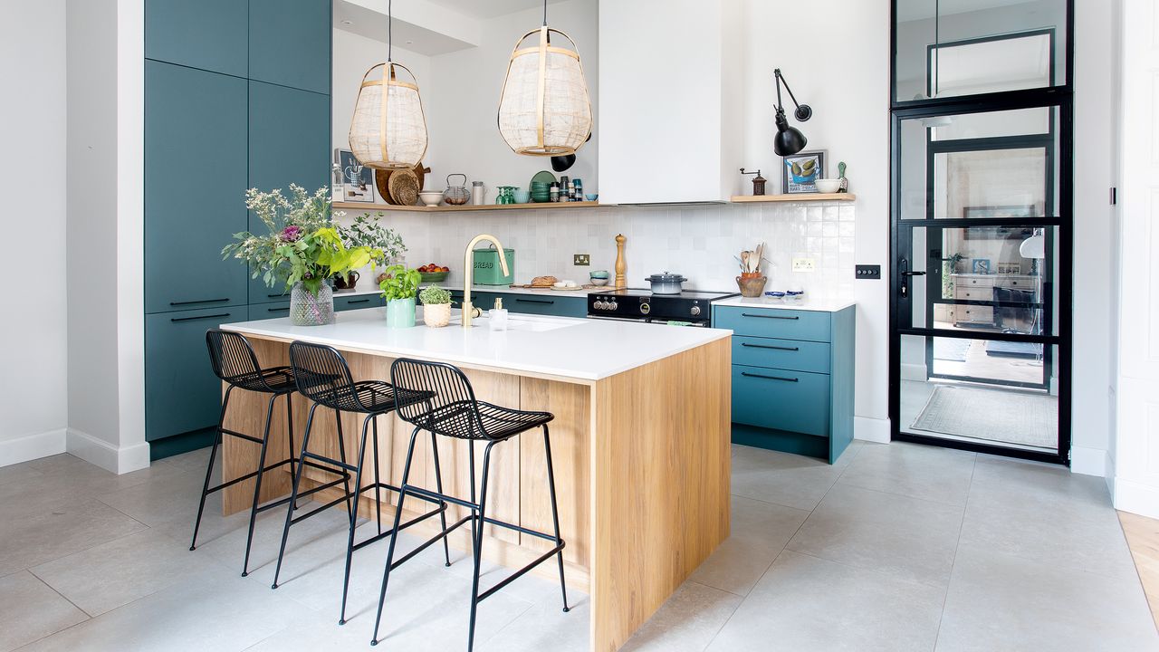 Light and modern kitchen with blue and wood surfaces, white worktops and statement pendant lights over a kitchen island