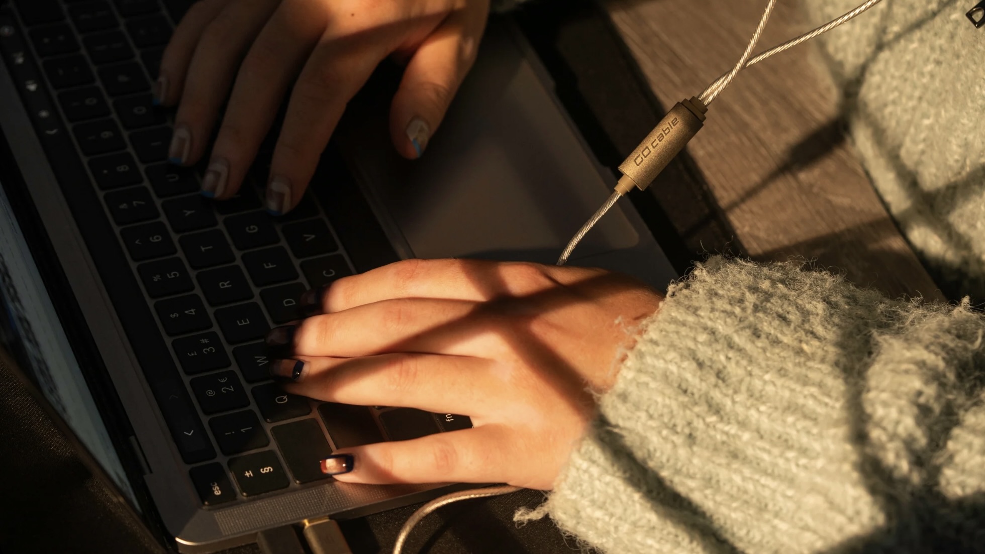 iFi Go cable plugged into laptop worn by person in jumper
