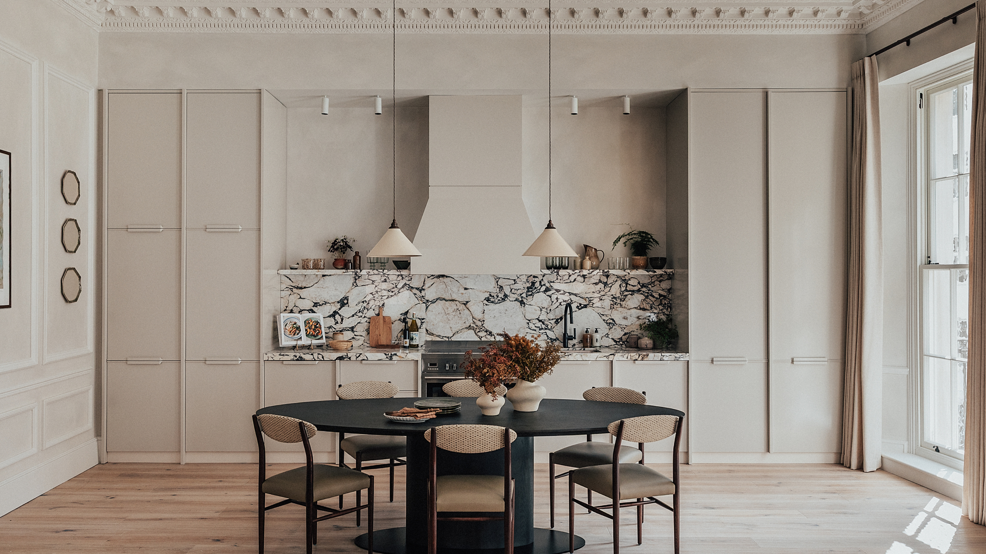 light filled kitchen with greige cabinets and marble counters